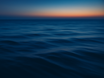 Ruhiges Meer mit Sonnenaufgang am Horizont